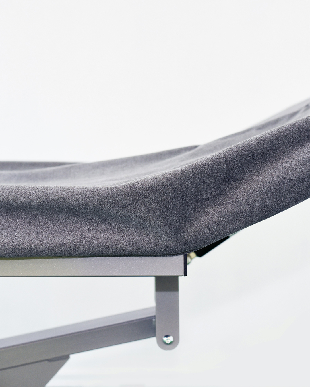 Mujer acostada en una camilla de tratamiento recibiendo terapia de compresión de piernas con presoterapia.